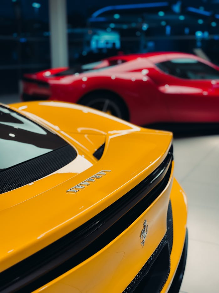 Close-up of luxury yellow and red sports cars showcased indoors.